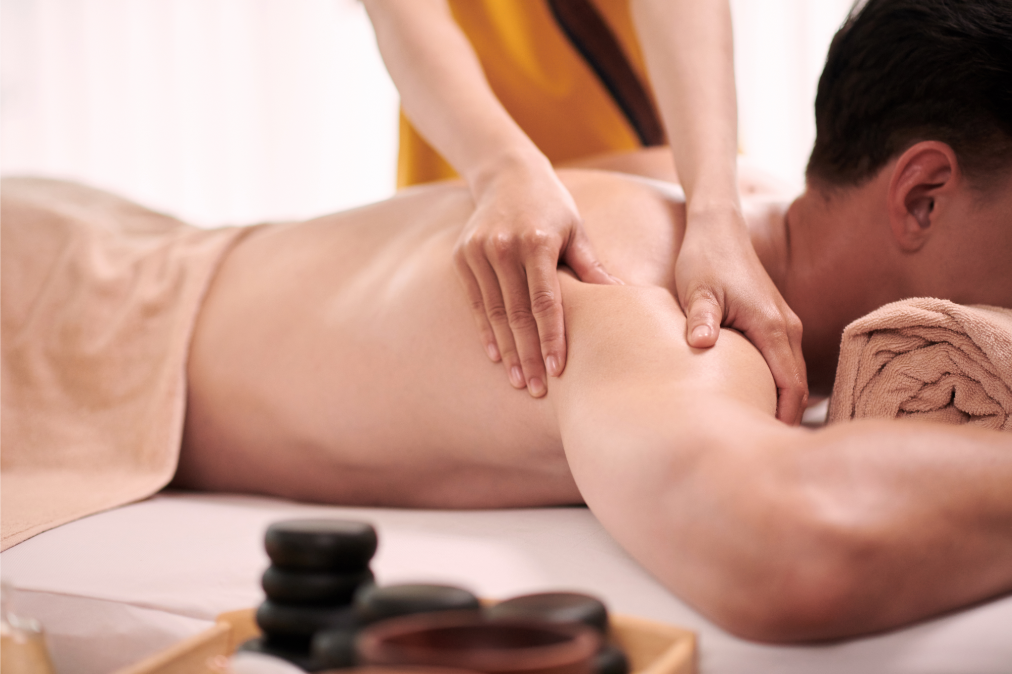 Closeup image of masseuse massaging shoulder of of male client