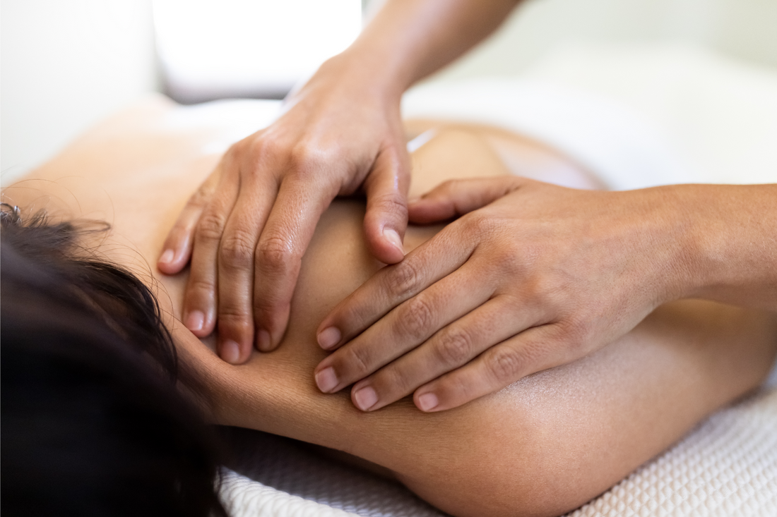Closeup of woman’s hands giving a relaxing back massage to female client. Spa treatment concept. Bodycare concept